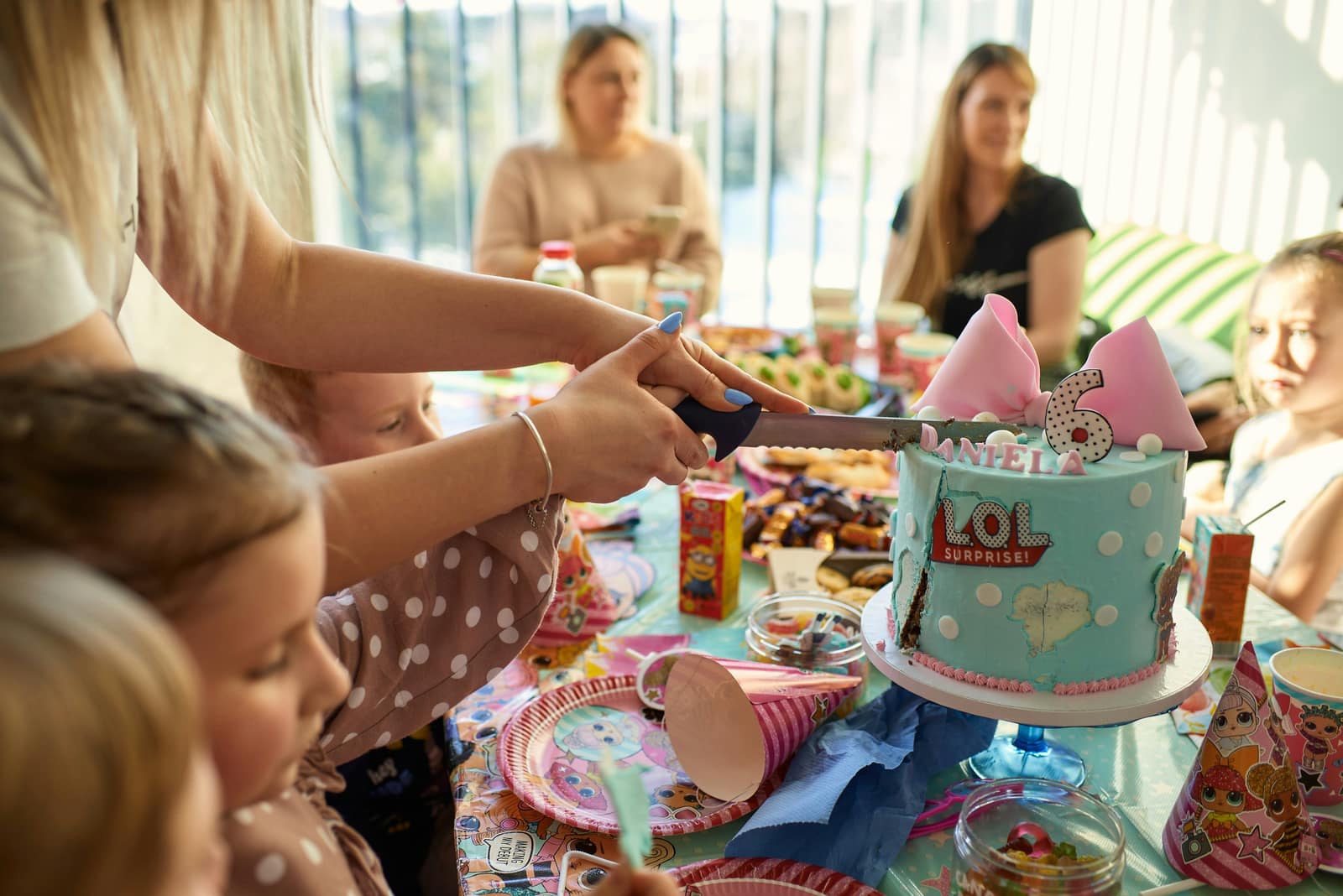 A birthday cake being cut at a children's party.